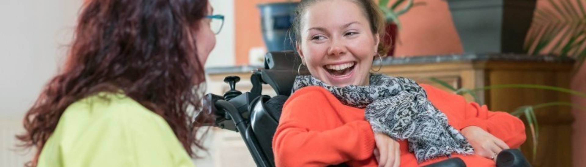 Professionnelle qui rigole avec une personne en situation de handicap