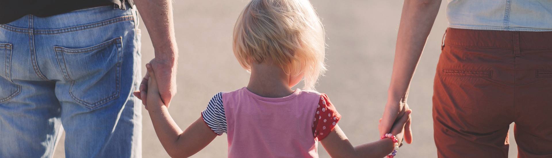 enfant qui tient la main de ses parents