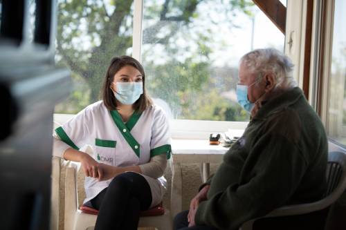 Une aide à domicile discute avec la personne aidée