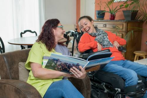 Une professionnelle montre un livre à une personne aidée